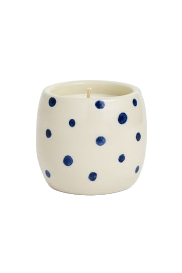 Ceramic candle with blue polka dots on a white background