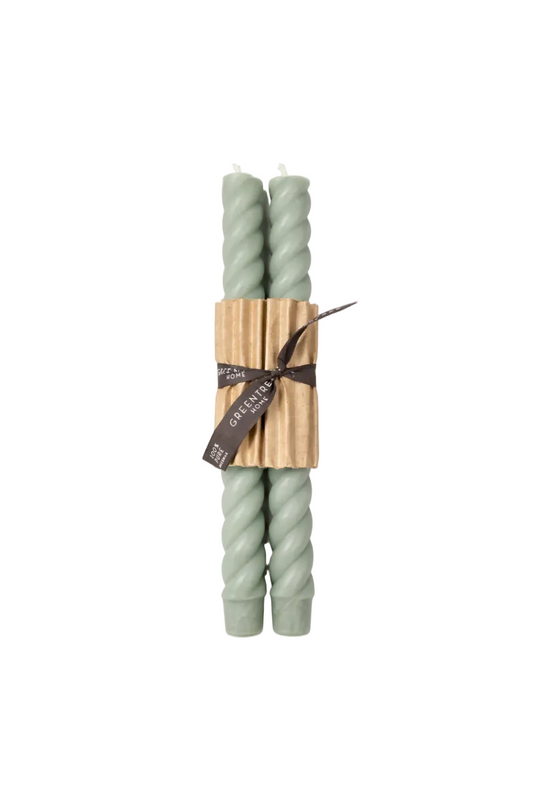 Two twisted candles wrapped in a wooden holder with a black ribbon on a white background