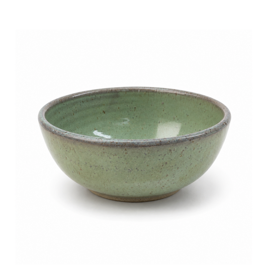 A handmade ceramic bowl with a speckled sage green glaze and a contrasting rustic brown rim, shown on a clean white background.