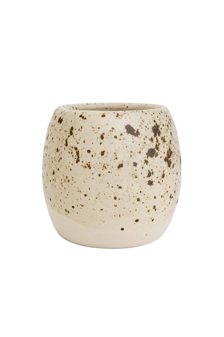 Speckled ceramic cup on a white background