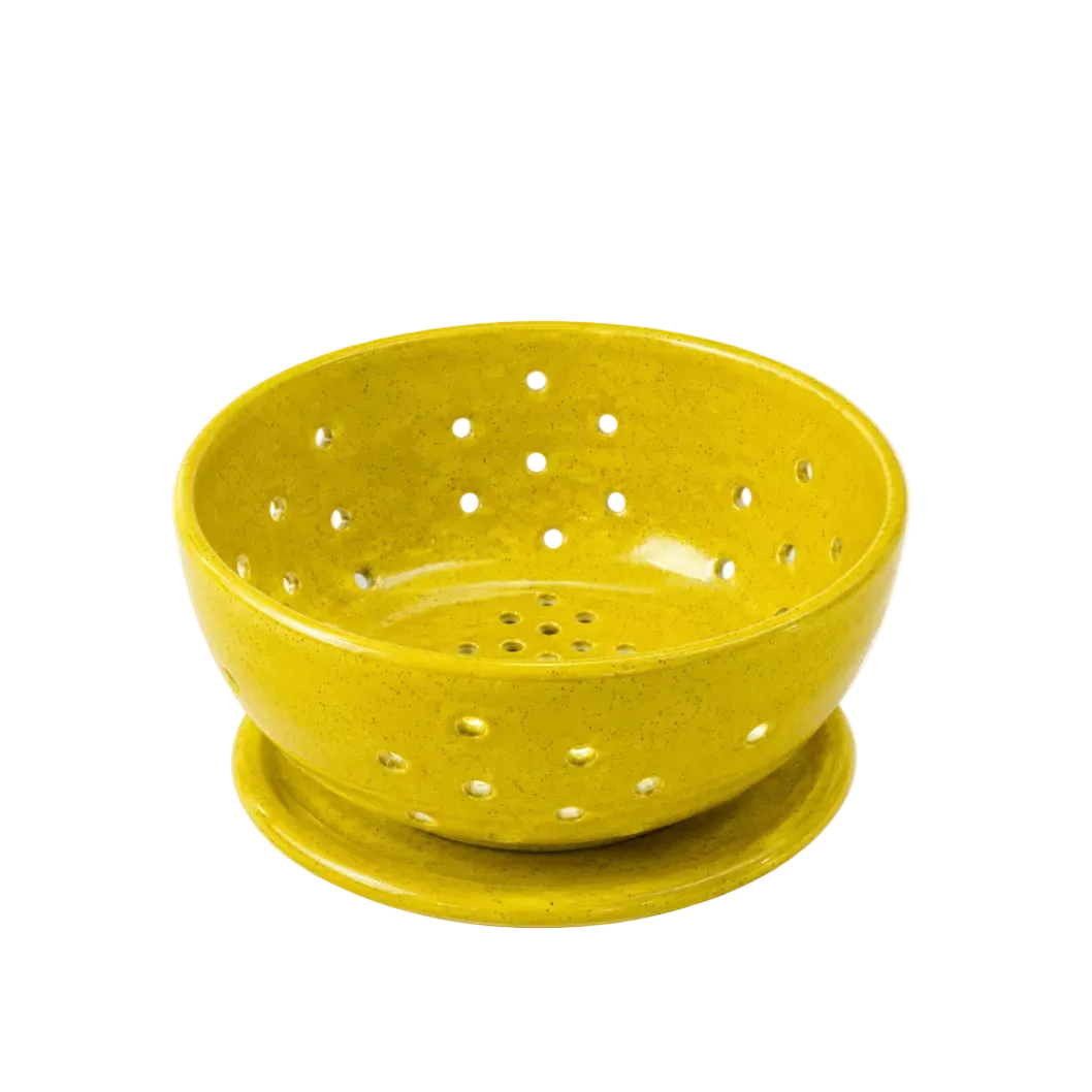 A yellow speckled ceramic berry 
bowl with a matching saucer, featuring multiple drainage holes, shown on a white background.