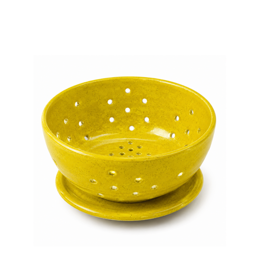 A yellow speckled ceramic berry 
bowl with a matching saucer, featuring multiple drainage holes, shown on a white background.