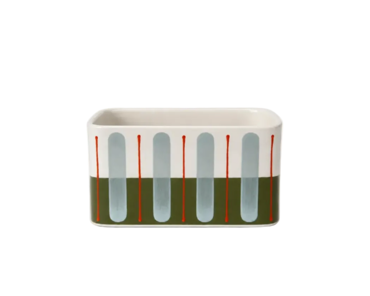 A rectangular ceramic planter with a modern abstract design, featuring a white top half with vertical light blue-gray arches and thin red lines, and a dark olive green bottom half.