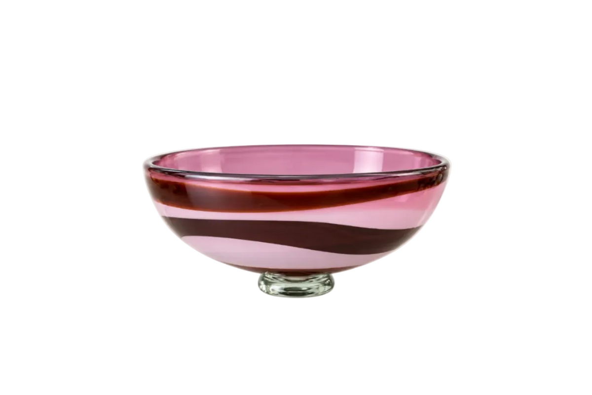 A clear glass pedestal bowl with horizontal bands of translucent pink, deep burgundy, and light pink, shown on a white background.