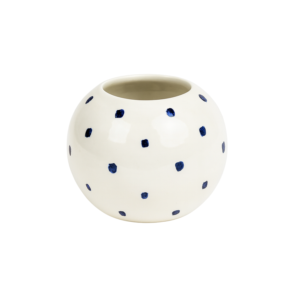 White ceramic pot with blue polka dots on a white background