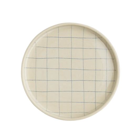 Round ceramic plate with grid pattern on a white background