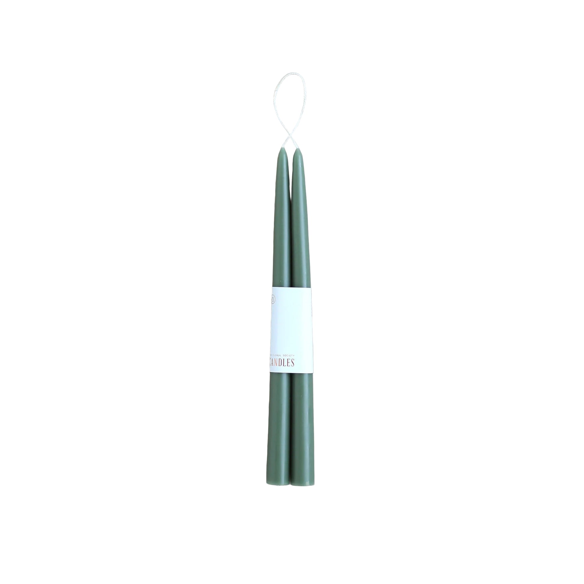 Two green candles on a white background with a visible brand label.