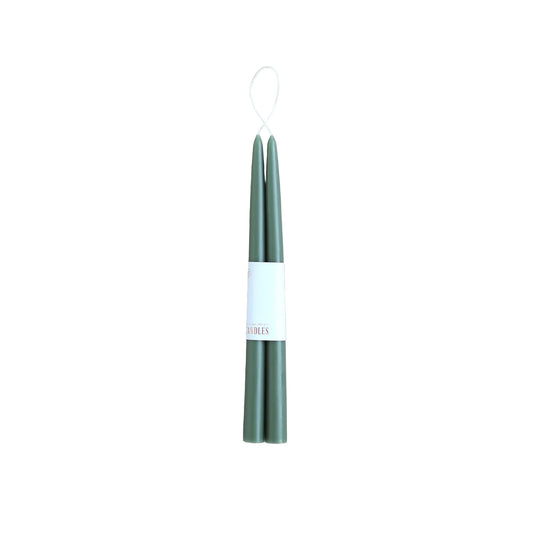 Two green candles on a white background with a visible brand label.