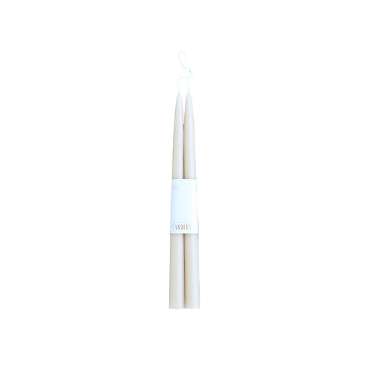 Two white candles with a label on a light gray background
