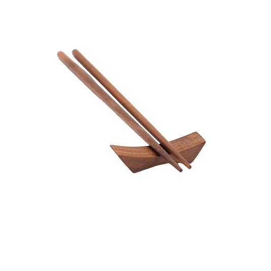 Wooden chopstick rest with two chopsticks on a white background