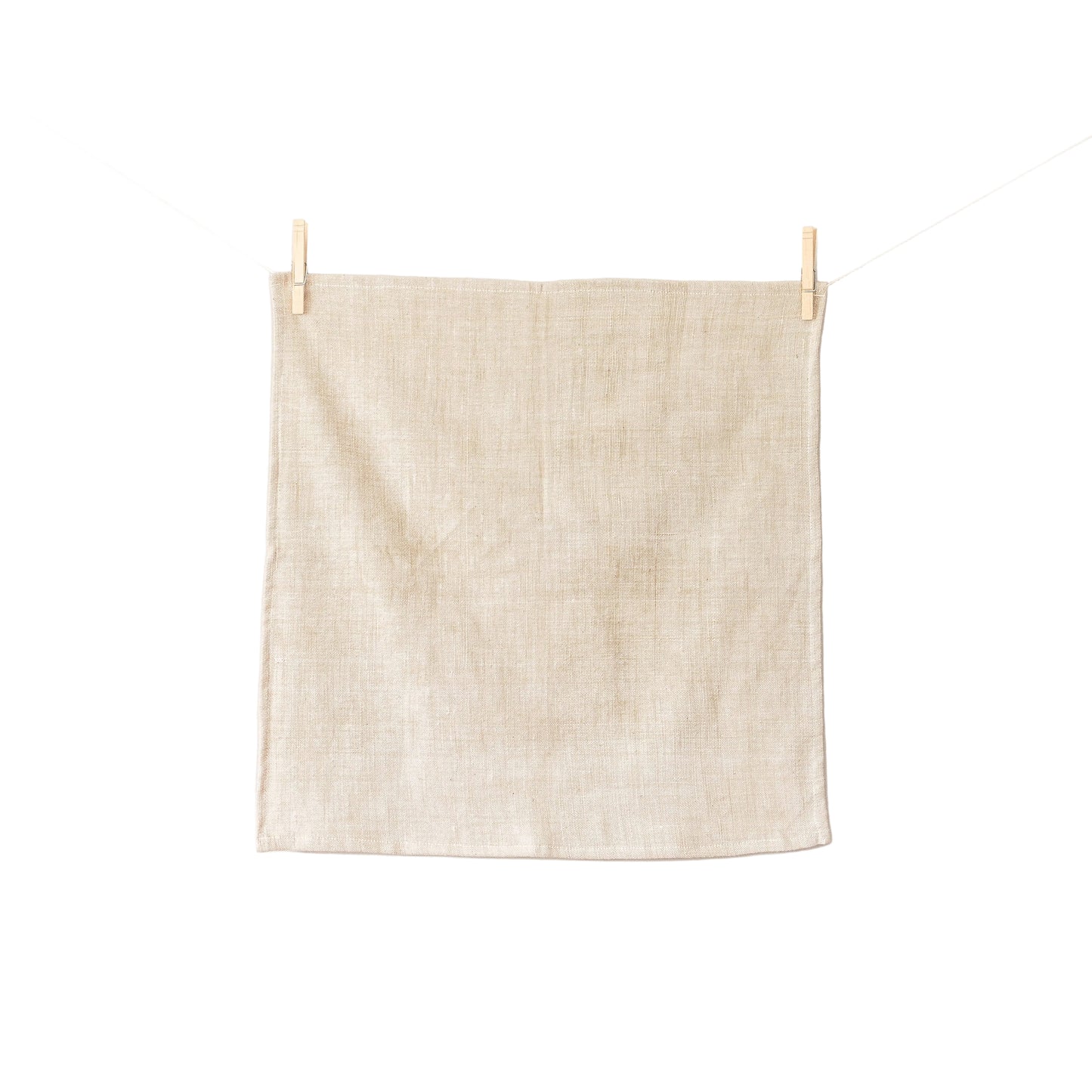 Beige towel hanging on a clothesline against a white background