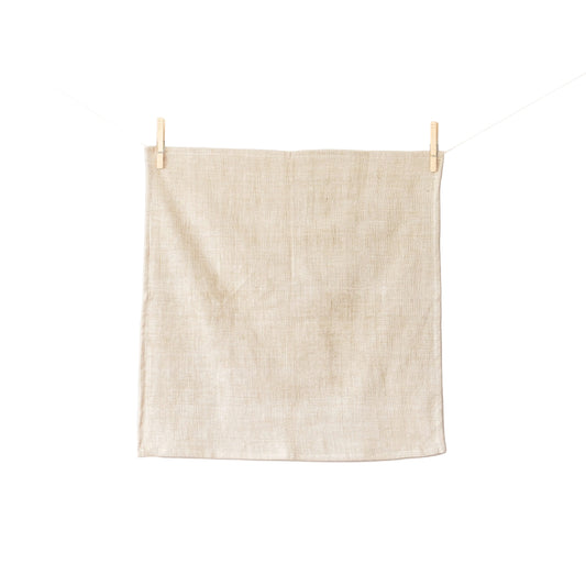 Beige towel hanging on a clothesline against a white background