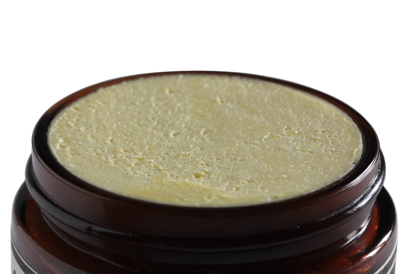 Close-up of a brown jar with a textured lid on a gray background