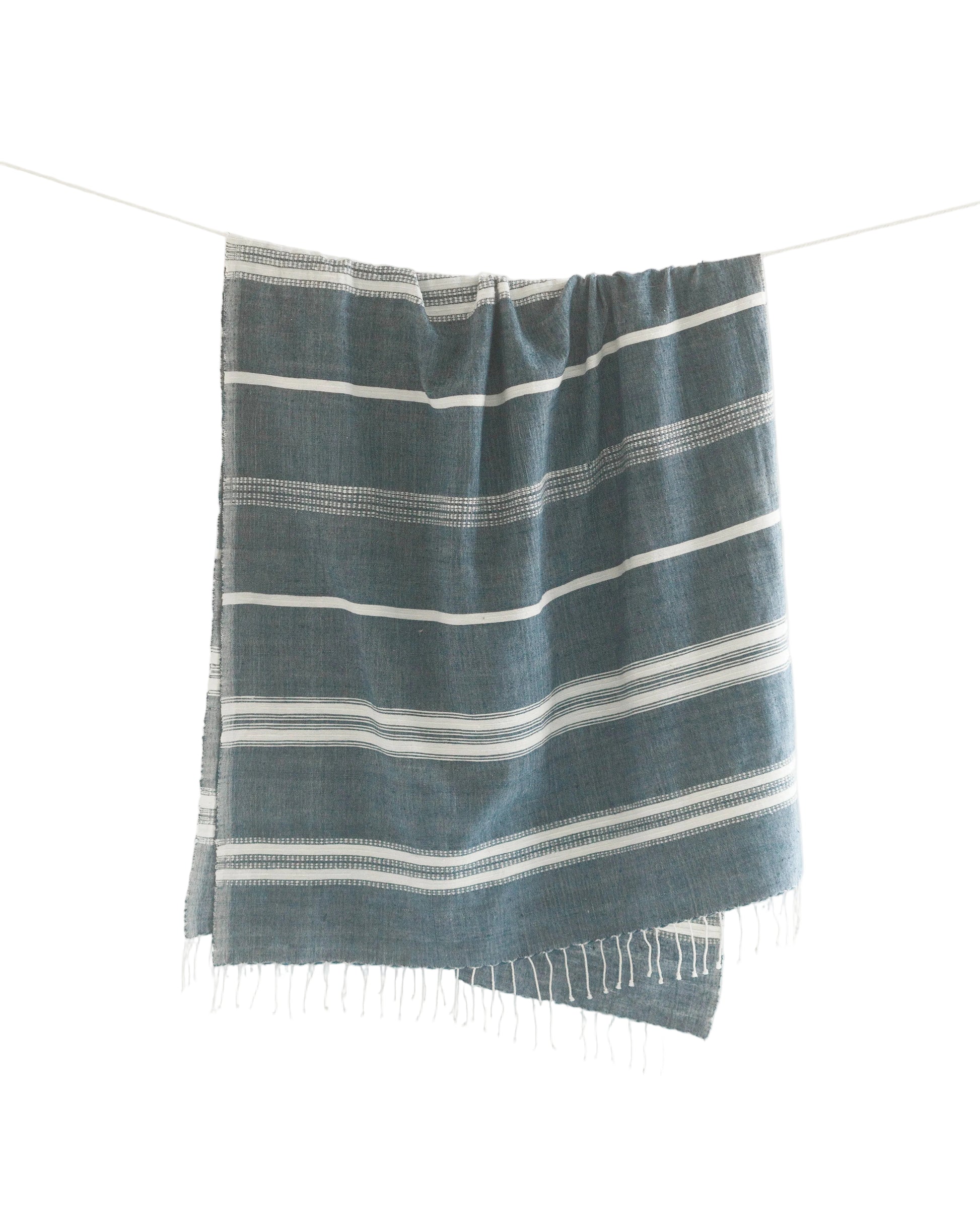 Striped blue and white towel on a light gray background