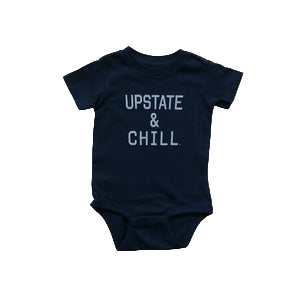 Navy blue baby onesie with 'UPSTATE & CHILL' text on a wooden surface