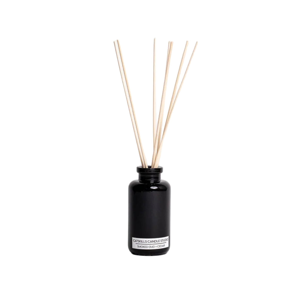 Black diffuser bottle with wooden sticks on a white background